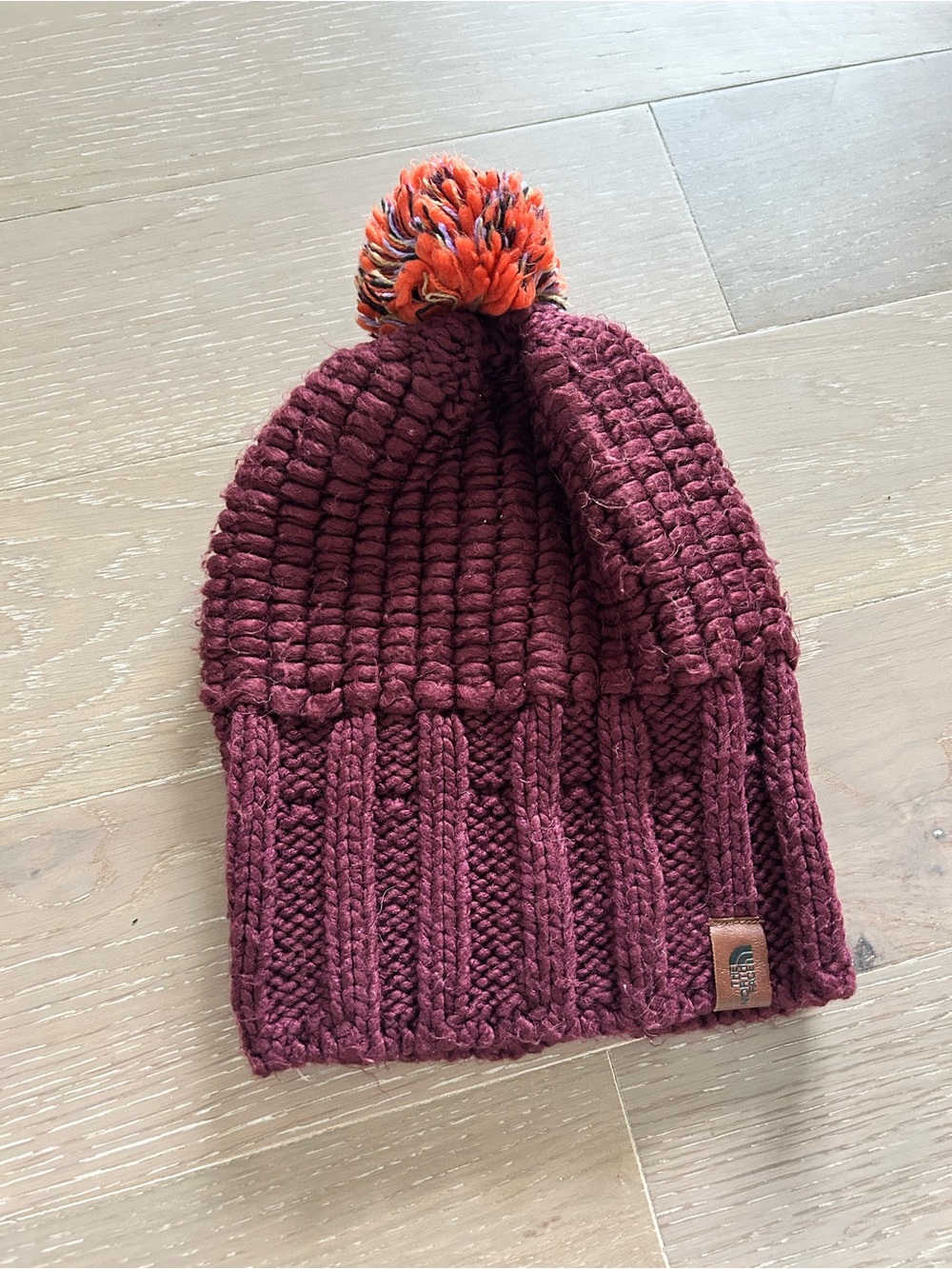 The North Face Knit Pom Beanie in Burgundy with Orange Pom